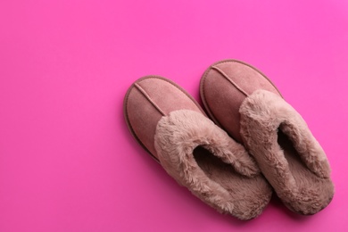 Photo of Pair of stylish soft slippers on pink background, flat lay. Space for text