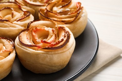 Photo of Freshly baked apple roses on white table, closeup. Beautiful dessert