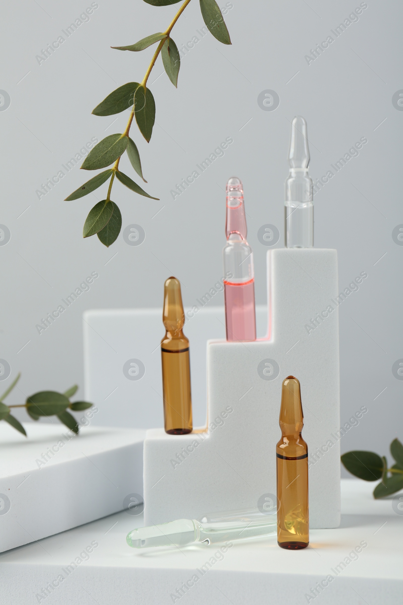 Photo of Stylish presentation of different skincare ampoules on white background