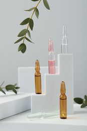 Photo of Stylish presentation of different skincare ampoules on white background