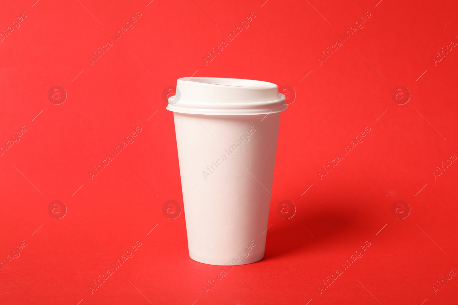 Photo of Takeaway paper coffee cup on red background