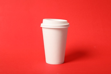 Photo of Takeaway paper coffee cup on red background