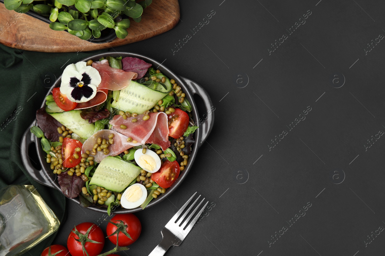 Photo of Bowl of salad with mung beans on black table, flat lay. Space for text