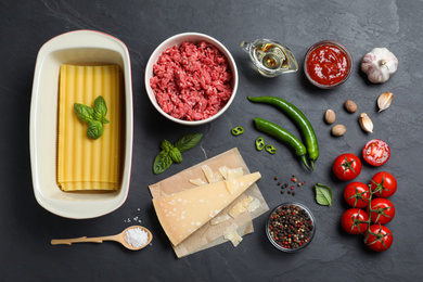 Fresh ingredients for lasagna on black table, flat lay