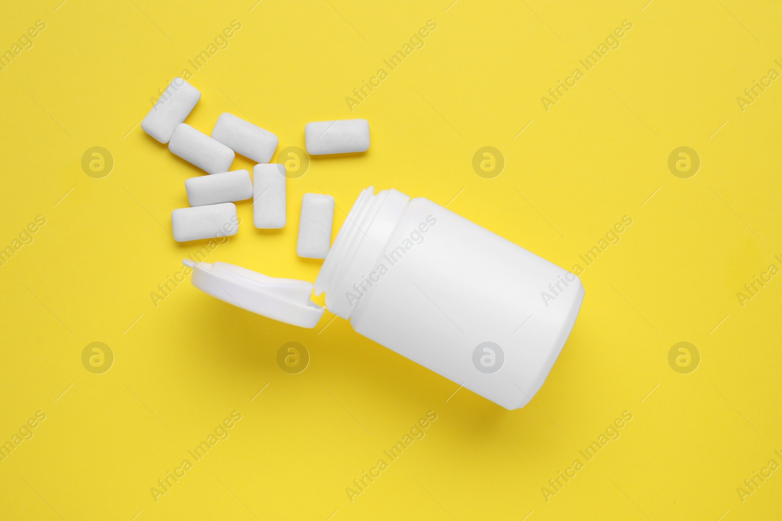 Photo of Jar with chewing gums on yellow background, flat lay