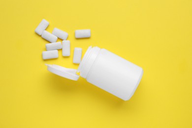 Photo of Jar with chewing gums on yellow background, flat lay