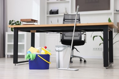 Photo of Cleaning service. Mop and buckets with supplies in office