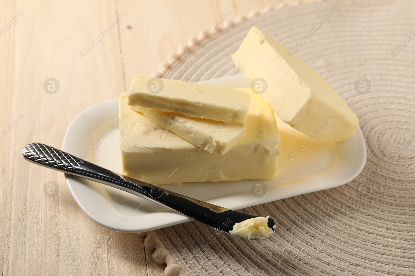 Photo of Tasty butter and knife on wooden table