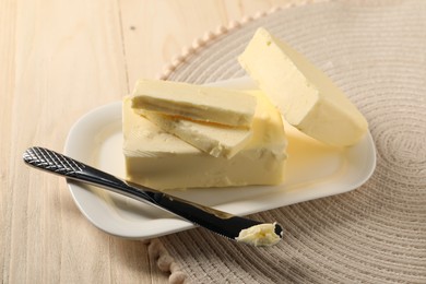 Tasty butter and knife on wooden table