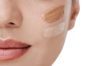 Photo of Woman with swatches of foundation on face against white background, closeup