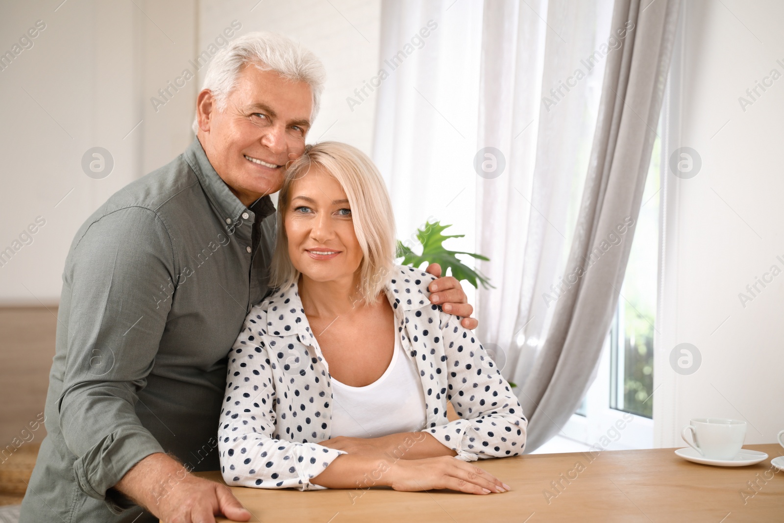 Photo of Portrait of affectionate senior couple at home. Space for text