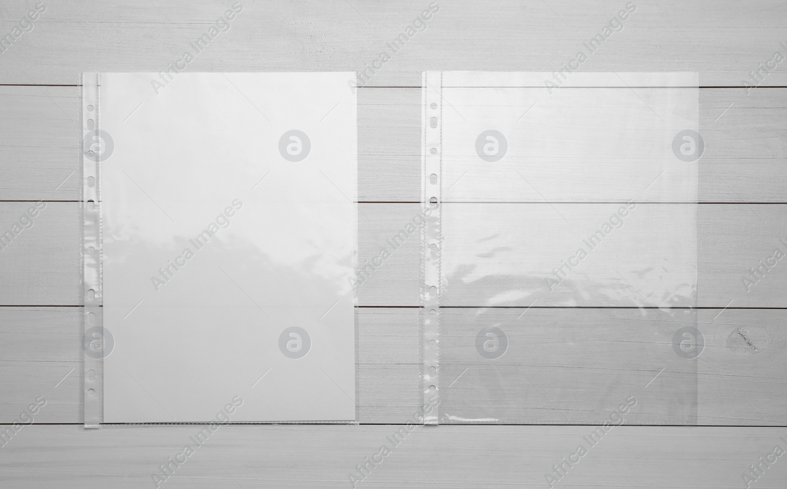 Photo of Punched pockets on white wooden table, flat lay