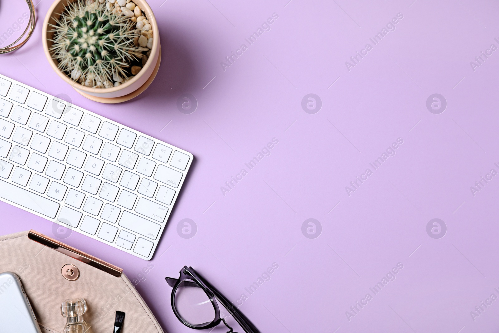 Photo of Flat lay composition with keyboard, cactus and fashion blogger's stuff on lilac background. Space for text