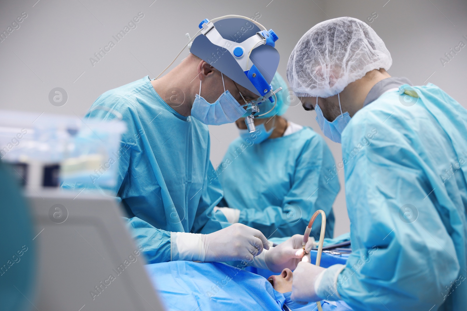 Photo of Professional doctors performing 
frontal sinus trephination in surgery room