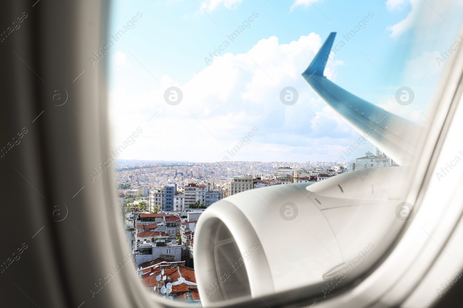 Image of Beautiful view of city with buildings through airplane window during flight