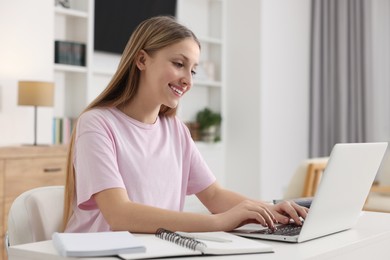 Photo of Online learning. Teenage girl typing on laptop at table