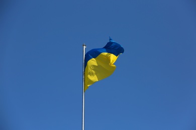 Photo of National flag of Ukraine fluttering against blue sky