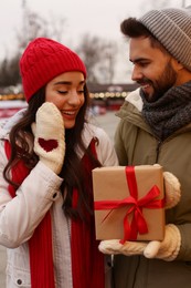 Photo of Lovely couple with Christmas present at winter fair