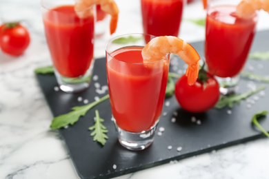 Photo of Shrimp cocktail with tomato sauce served on slate board