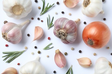 Photo of Fresh garlic, onion, rosemary and peppercorns on white background, flat lay