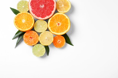 Different citrus fruits with fresh leaves on white background, top view. Space for text