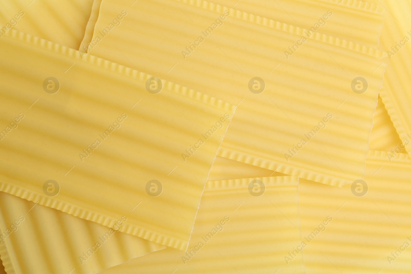 Photo of Pile of uncooked lasagna sheets as background, top view