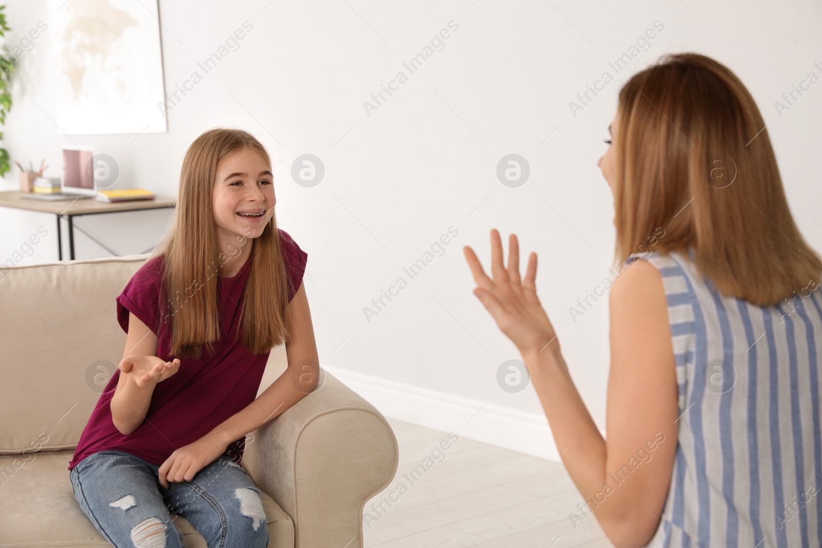 Photo of Mother talking with her teenager daughter at home