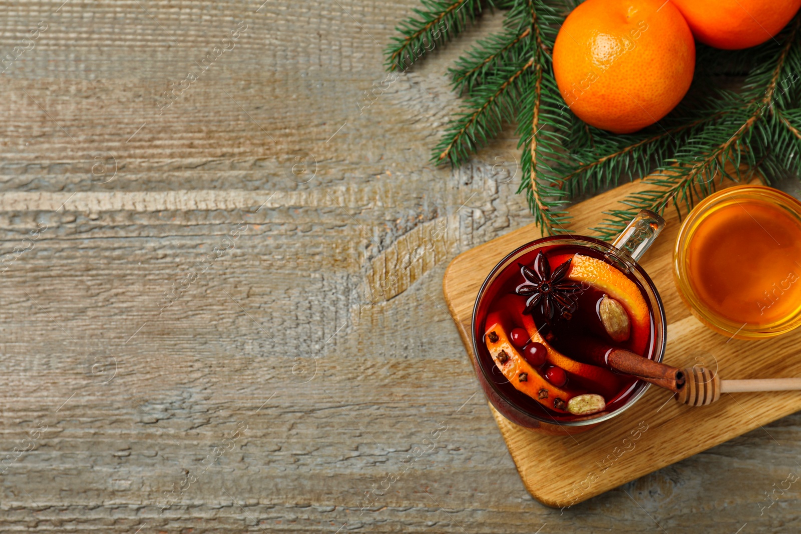 Photo of Glass cup of tasty mulled wine on wooden background, flat lay. Space for text