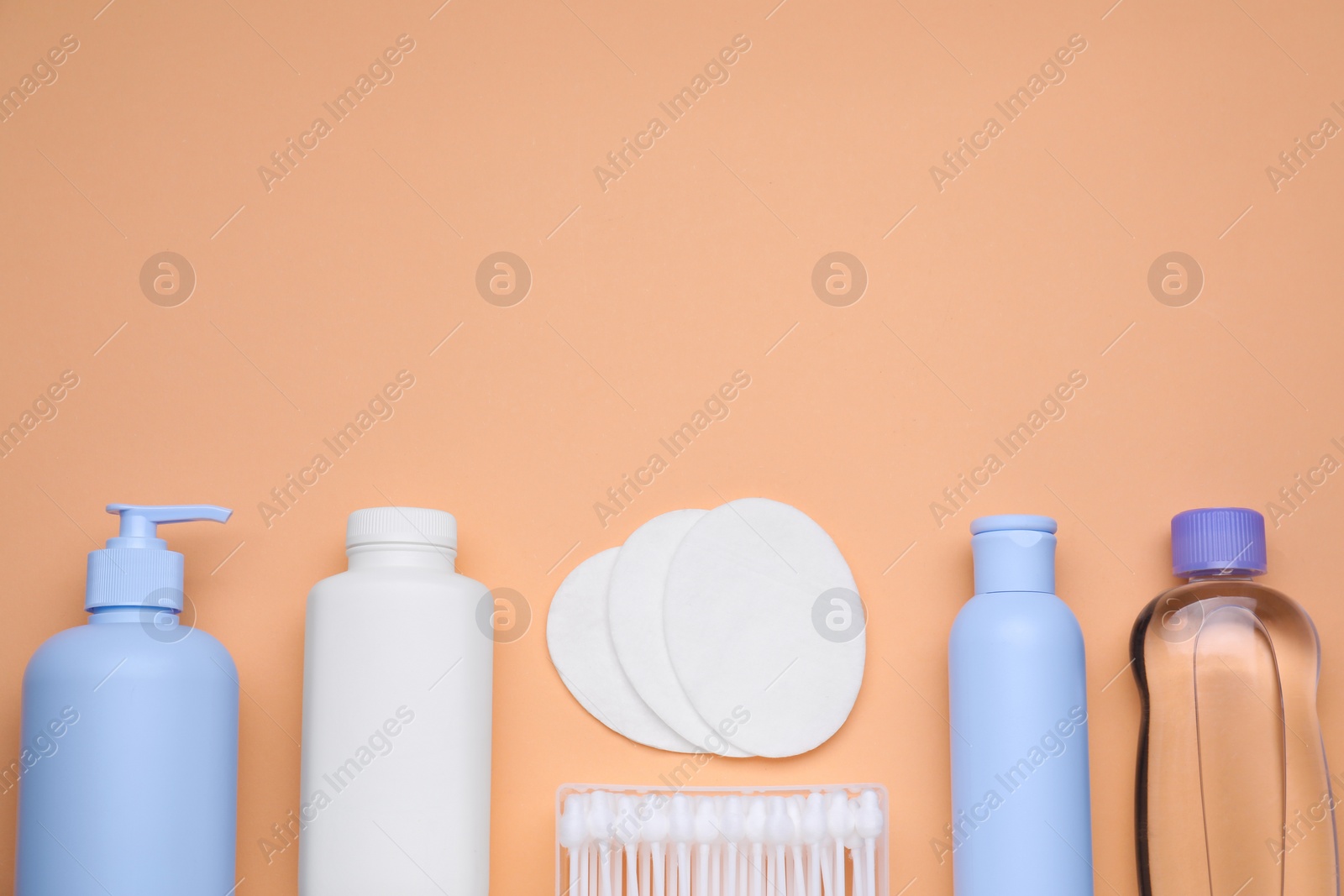 Photo of Flat lay composition with baby care products on pale orange background, space for text
