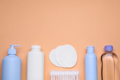 Flat lay composition with baby care products on pale orange background, space for text