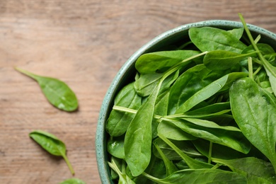 Photo of Fresh green healthy spinach on wooden table, top view