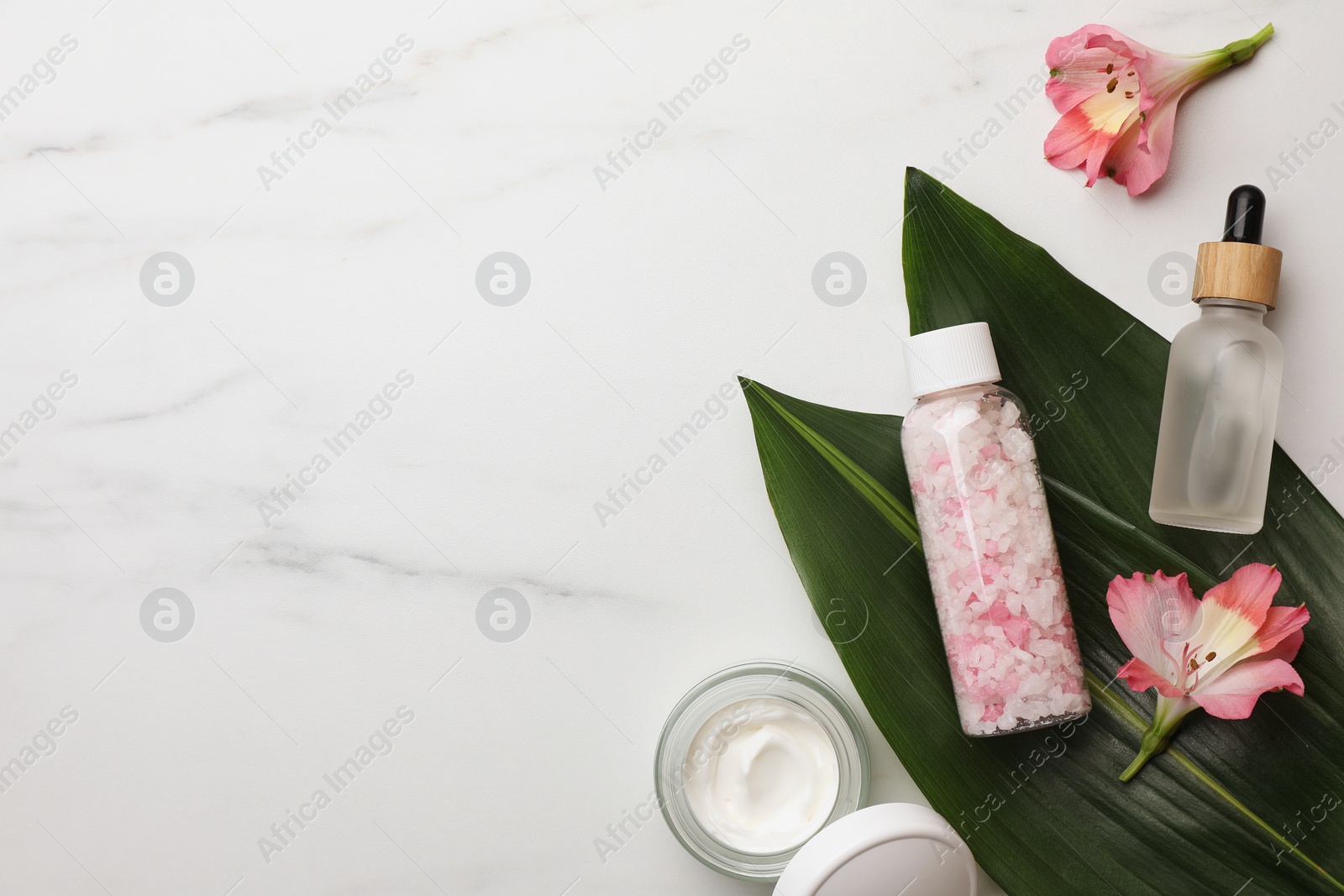 Photo of Flat lay composition with spa products and flowers on white marble table. Space for text