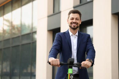 Businessman with modern kick scooter on city street, space for text