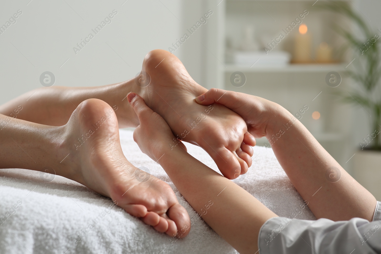 Photo of Woman receiving foot massage in spa salon, closeup