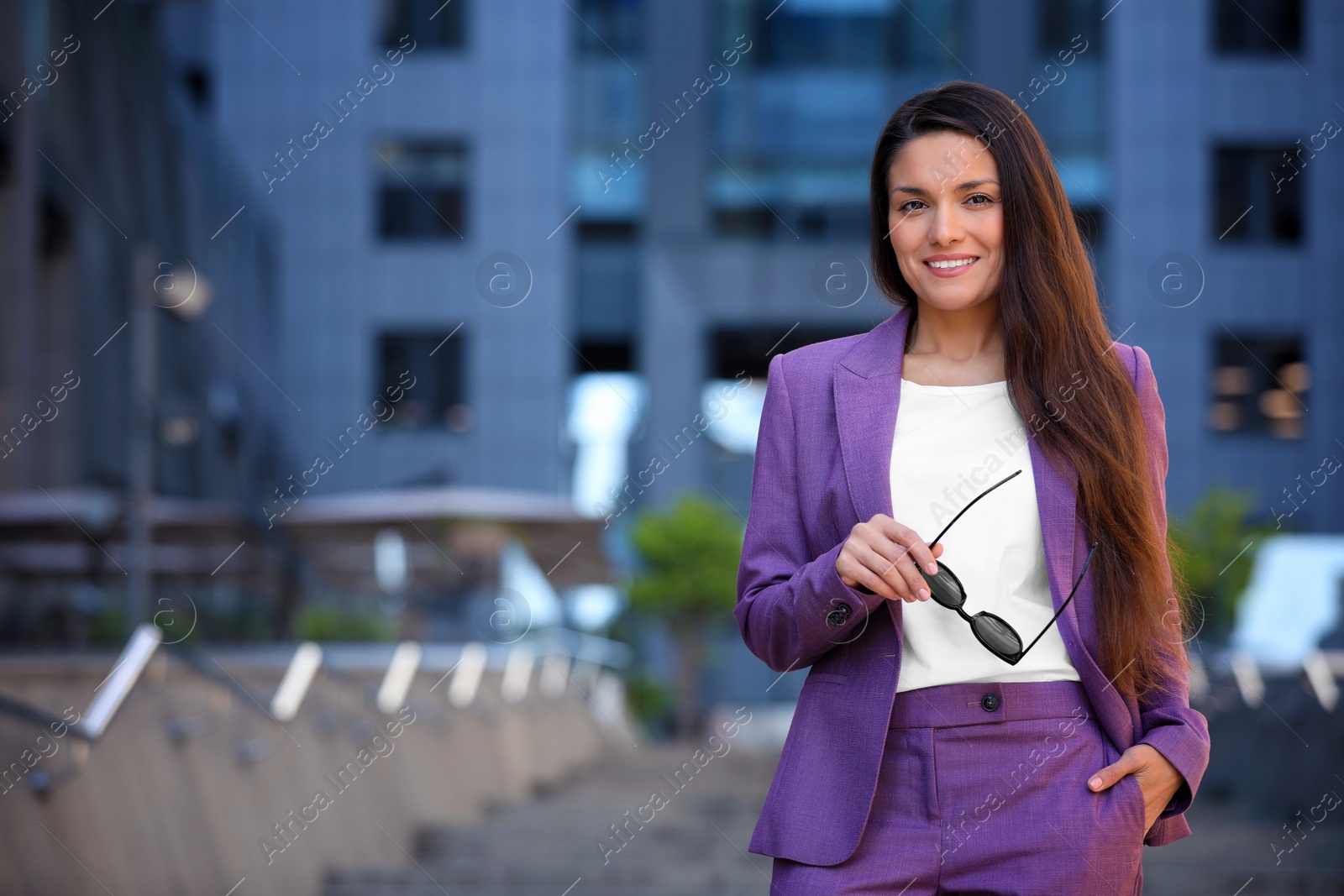 Photo of Beautiful businesswoman with sunglasses on city street. Space for text