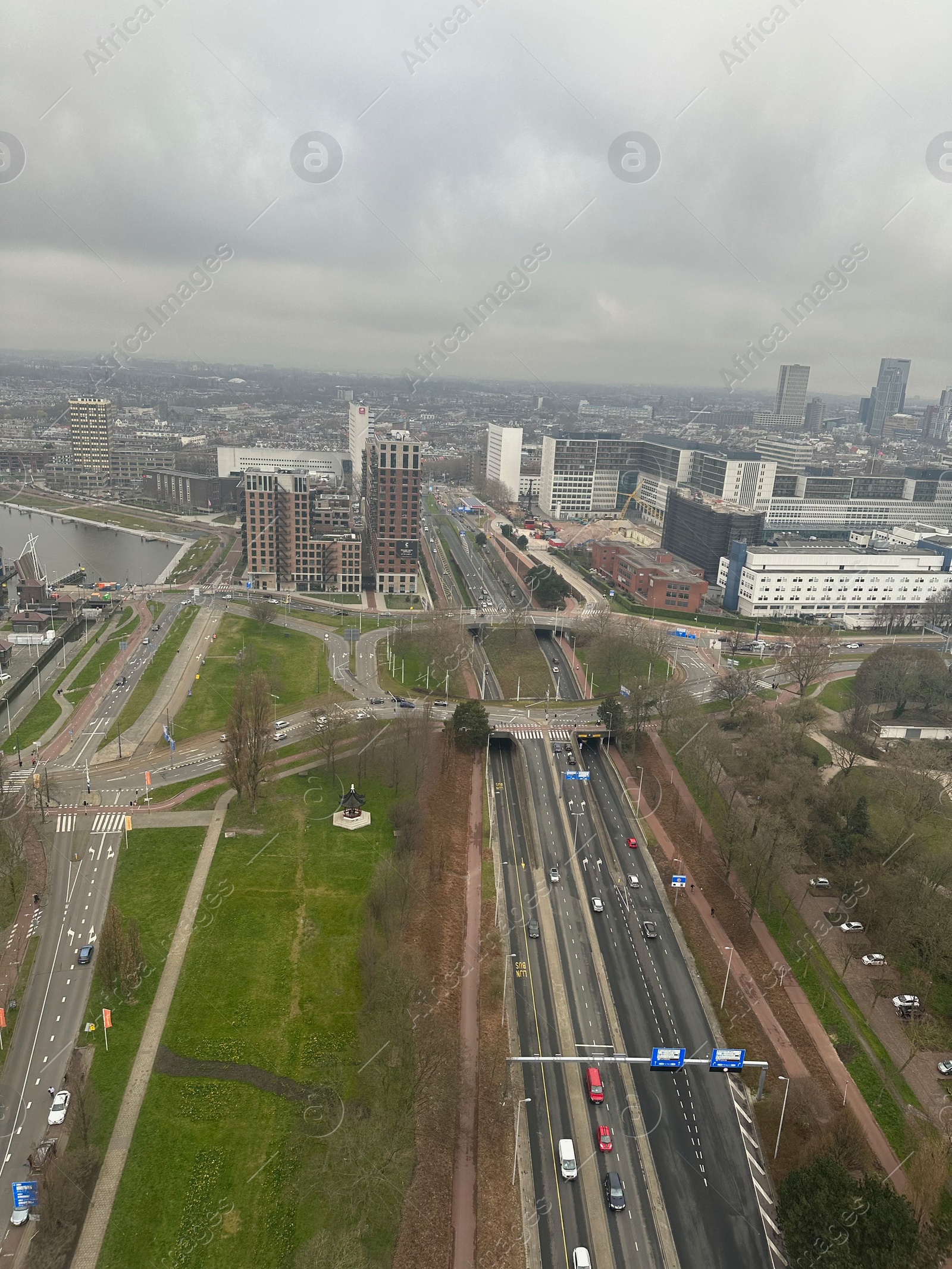 Photo of Picturesque view of city with modern buildings and highway on cloudy day