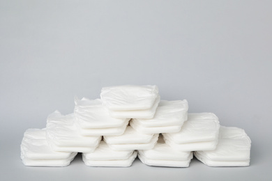 Photo of Pile of baby diapers on light grey background