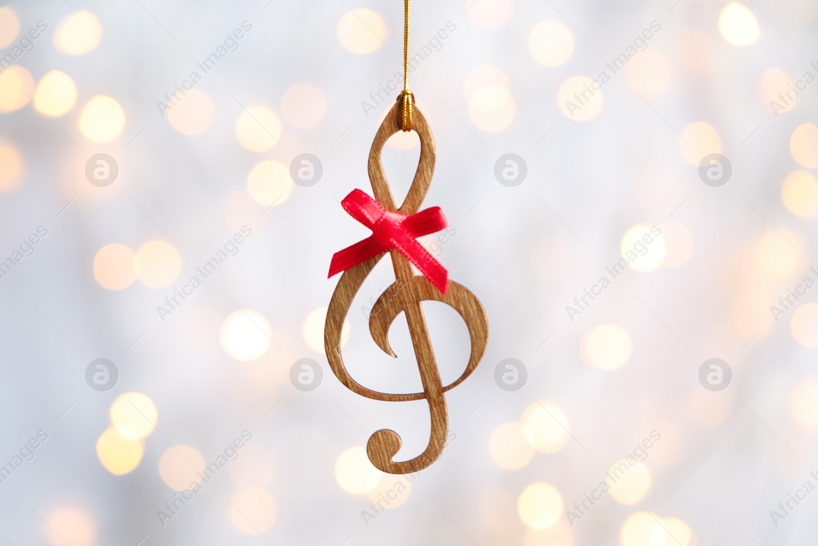 Photo of Wooden treble clef against blurred lights. Christmas music