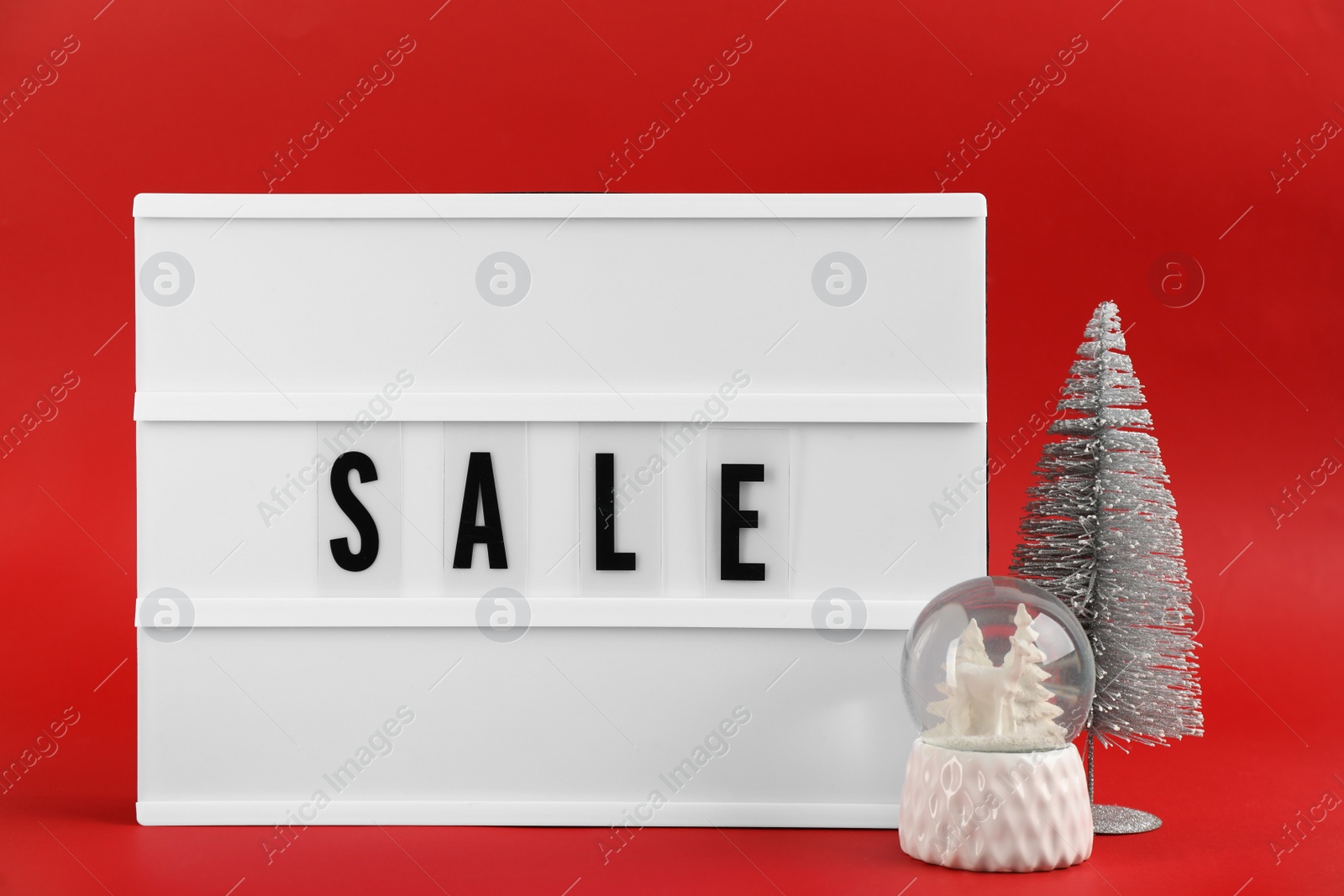 Photo of Lightbox with word Sale and Christmas decor on red background