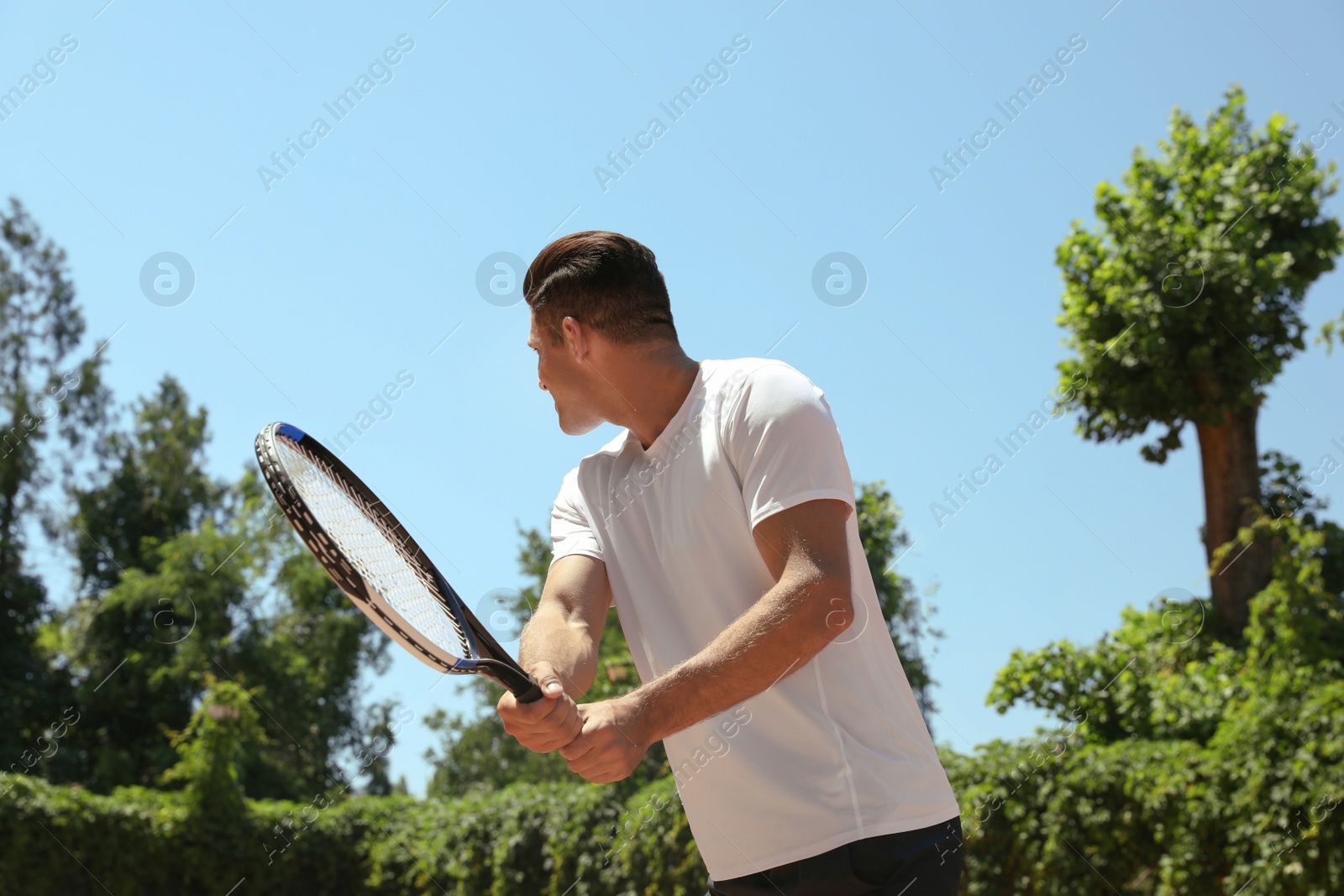 Photo of Man playing tennis on court during sunny day