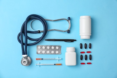 Photo of Flat lay composition with medical equipment and pills on color background