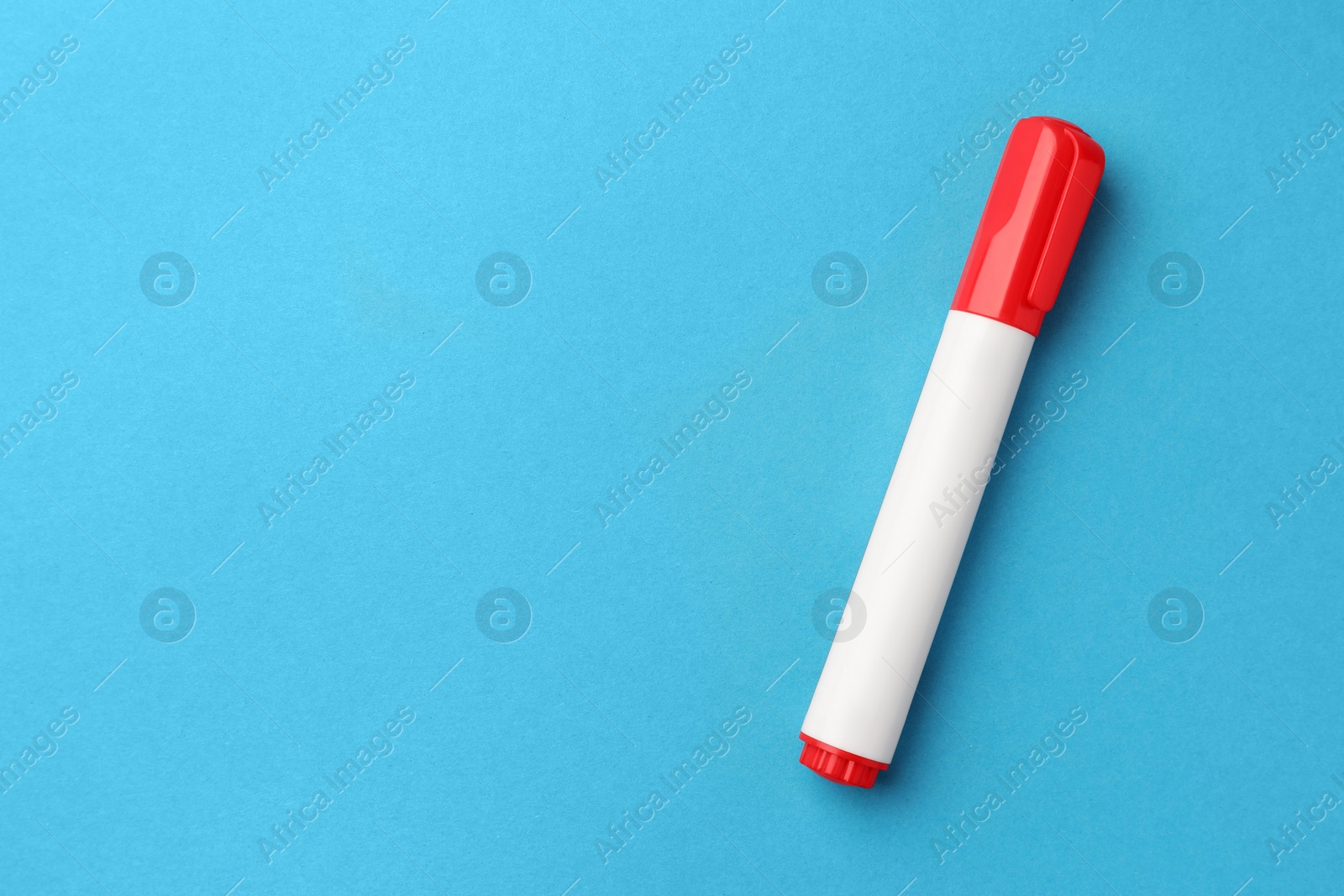 Photo of Bright red marker on light blue background, top view. Space for text