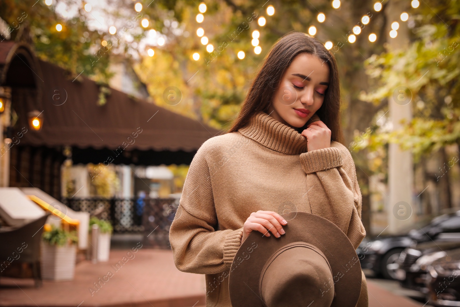 Photo of Young woman wearing stylish clothes on city street, space for text. Autumn look