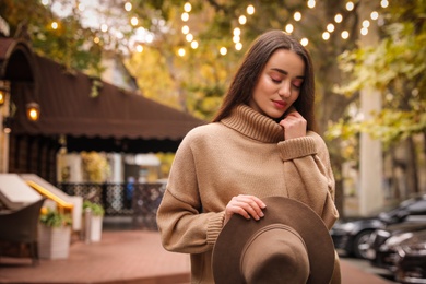 Young woman wearing stylish clothes on city street, space for text. Autumn look