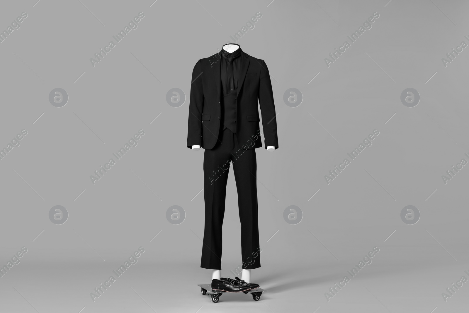 Photo of Male mannequin dressed in stylish black suit on grey background