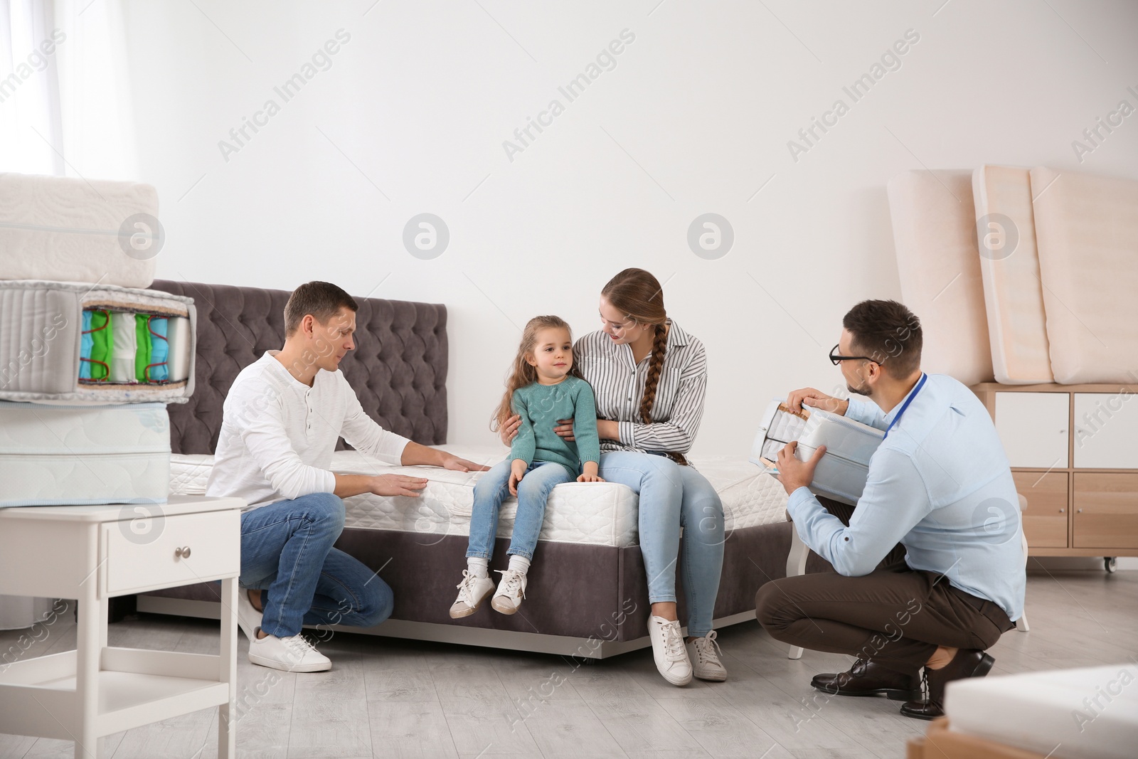 Photo of Salesman showing family section of mattress at store