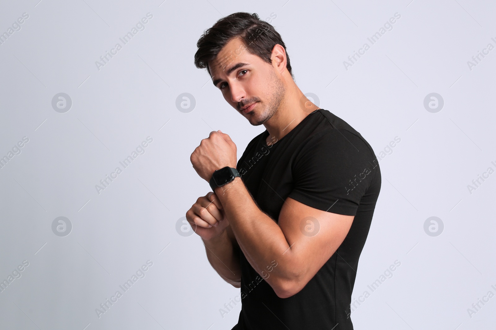 Photo of Portrait of handsome young man in black t-shirt on grey background