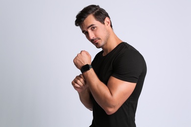 Portrait of handsome young man in black t-shirt on grey background