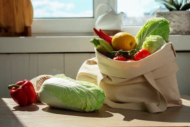 Photo of Fresh Chinese cabbage and other products on wooden table indoors