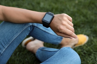 Photo of Woman with modern smart watch outdoors, closeup